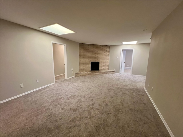 unfurnished living room featuring carpet floors and a brick fireplace