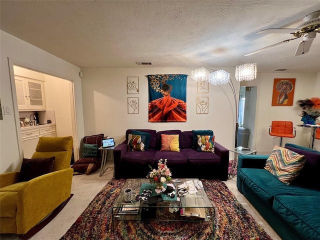 carpeted living room featuring ceiling fan and a textured ceiling