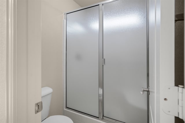 bathroom with toilet and an enclosed shower