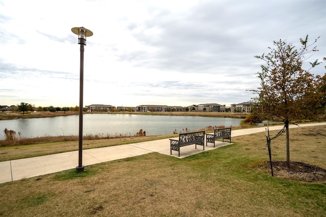 surrounding community featuring a water view and a lawn