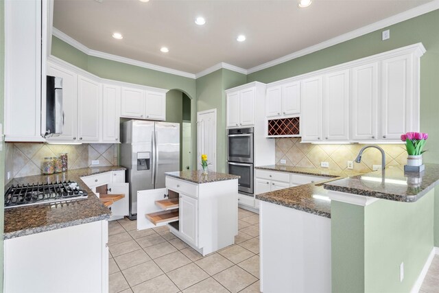 kitchen featuring crown molding, ceiling fan, appliances with stainless steel finishes, light tile patterned flooring, and white cabinetry