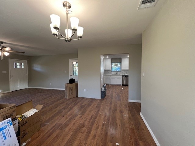 interior space featuring ceiling fan with notable chandelier and dark wood-type flooring