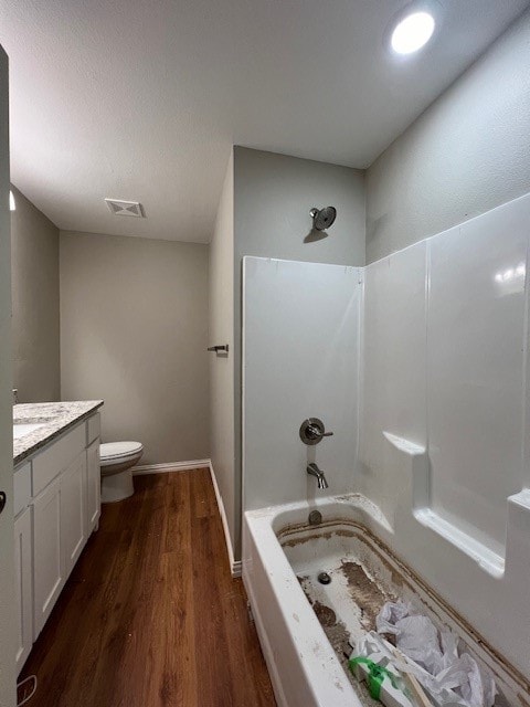 full bathroom featuring bathing tub / shower combination, hardwood / wood-style floors, vanity, and toilet