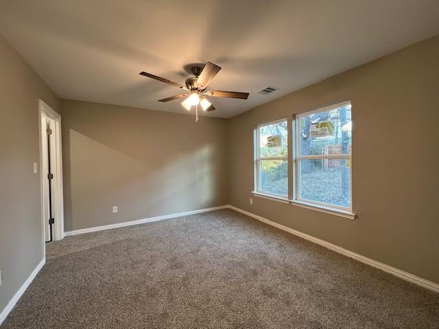 empty room featuring carpet flooring and ceiling fan