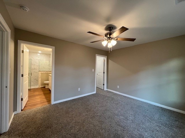 unfurnished bedroom featuring ceiling fan, light carpet, and connected bathroom