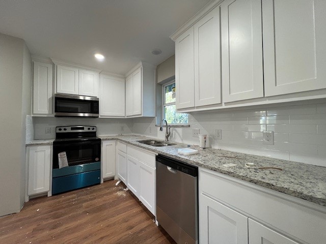 kitchen with stainless steel appliances, white cabinetry, dark wood-type flooring, and sink