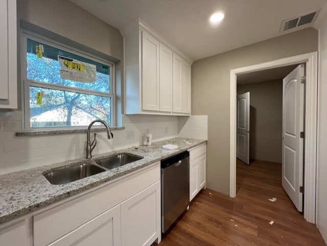 kitchen featuring light stone countertops, dark wood-type flooring, sink, dishwasher, and white cabinetry