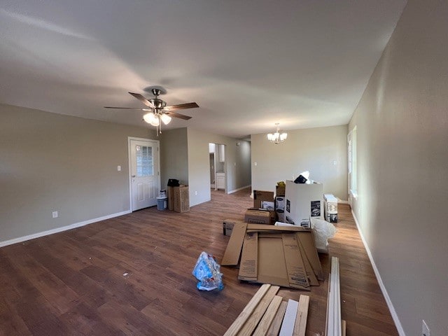 living room with ceiling fan with notable chandelier, dark hardwood / wood-style flooring, and plenty of natural light