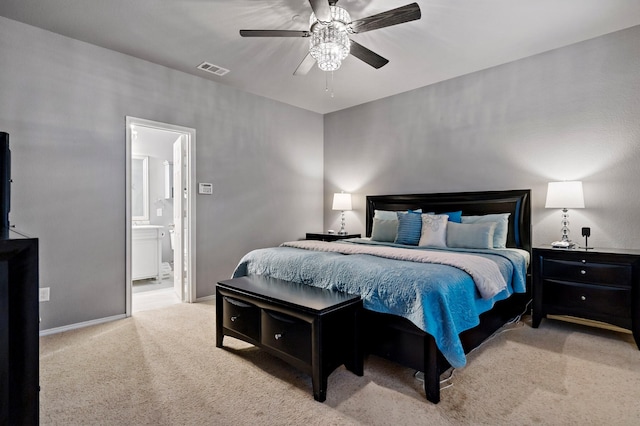 carpeted bedroom with ensuite bath, baseboards, visible vents, and ceiling fan