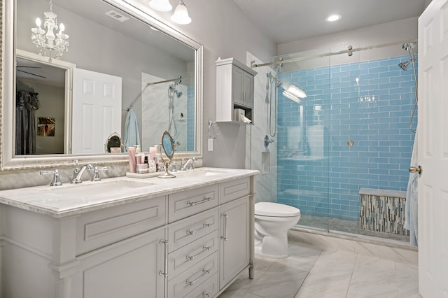 bathroom with toilet, vanity, an enclosed shower, and an inviting chandelier