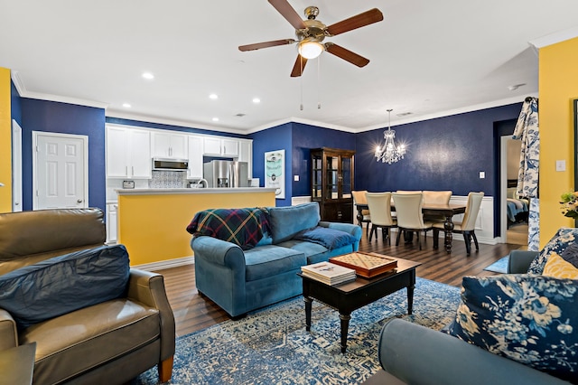 living room featuring ceiling fan with notable chandelier, crown molding, and dark wood-type flooring