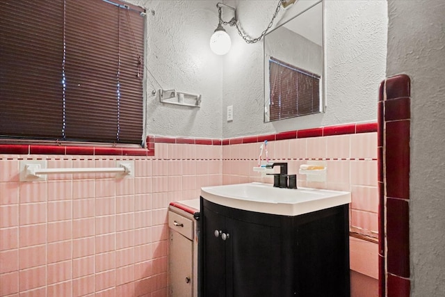 bathroom featuring vanity and tile walls