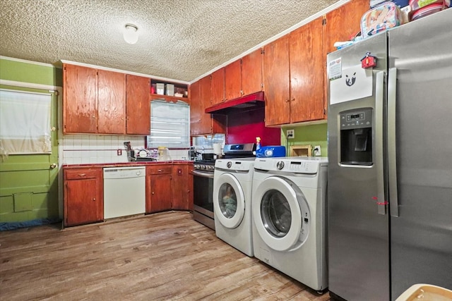 laundry area featuring washing machine and clothes dryer, sink, crown molding, a textured ceiling, and light hardwood / wood-style floors