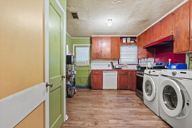 laundry room featuring sink, light hardwood / wood-style flooring, independent washer and dryer, ornamental molding, and a textured ceiling