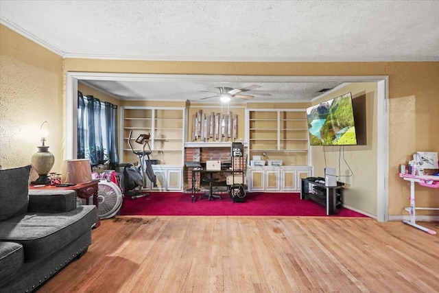 living room with hardwood / wood-style flooring, ceiling fan, crown molding, and a textured ceiling