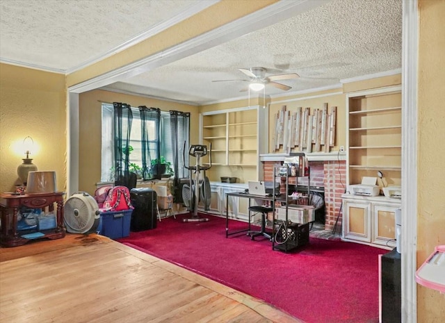 misc room with ornamental molding, wood-type flooring, ceiling fan, and a textured ceiling