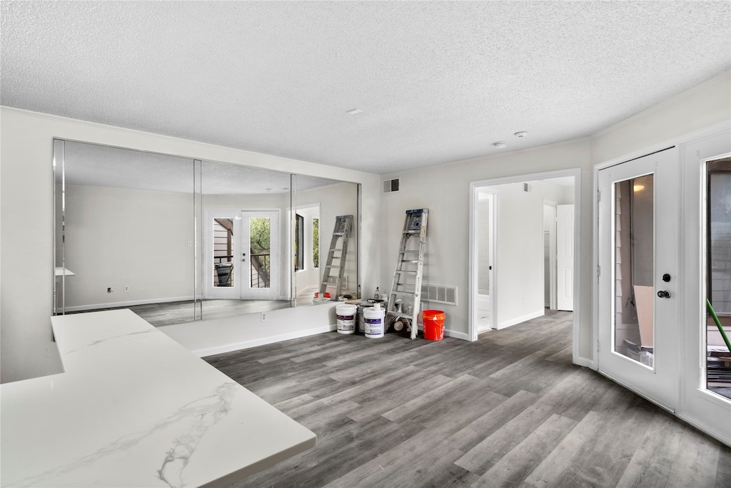 interior space with hardwood / wood-style flooring, french doors, and a textured ceiling