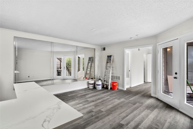 interior space featuring french doors, hardwood / wood-style floors, and a textured ceiling