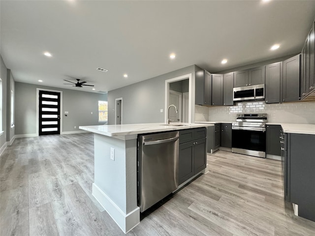 kitchen featuring light hardwood / wood-style floors, sink, an island with sink, and appliances with stainless steel finishes