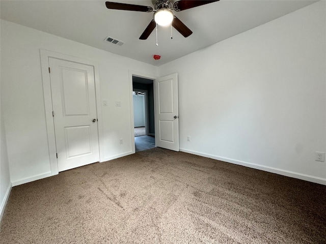 unfurnished bedroom with dark carpet and ceiling fan