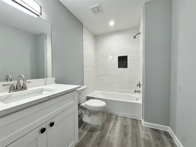 full bathroom with toilet, vanity, tiled shower / bath combo, and hardwood / wood-style flooring