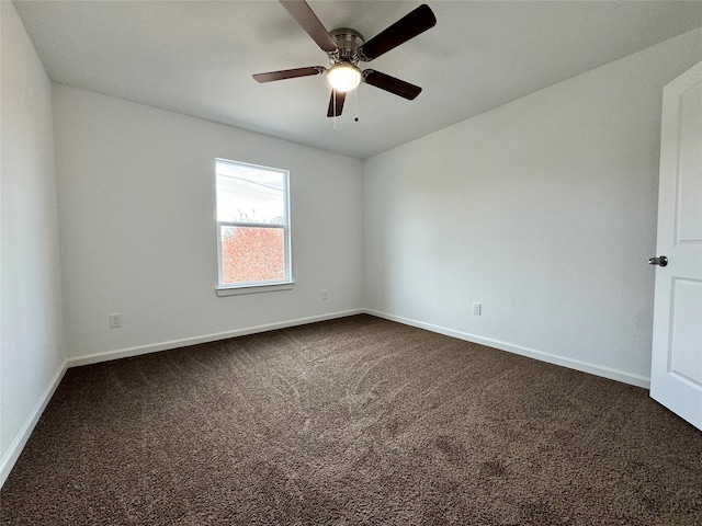 empty room featuring dark carpet and ceiling fan