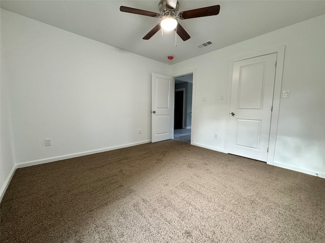 unfurnished bedroom featuring dark colored carpet and ceiling fan