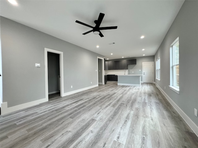 unfurnished living room with light hardwood / wood-style floors and ceiling fan