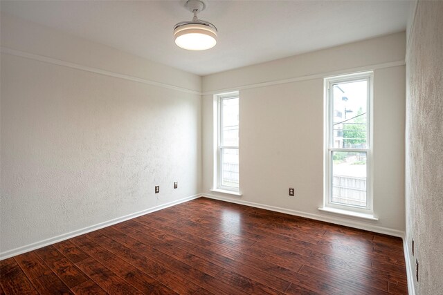 unfurnished room with dark hardwood / wood-style floors and a wealth of natural light