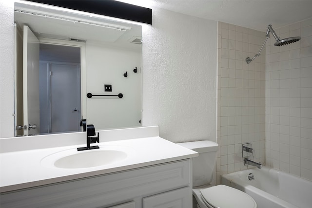 full bathroom with vanity, tiled shower / bath combo, and toilet