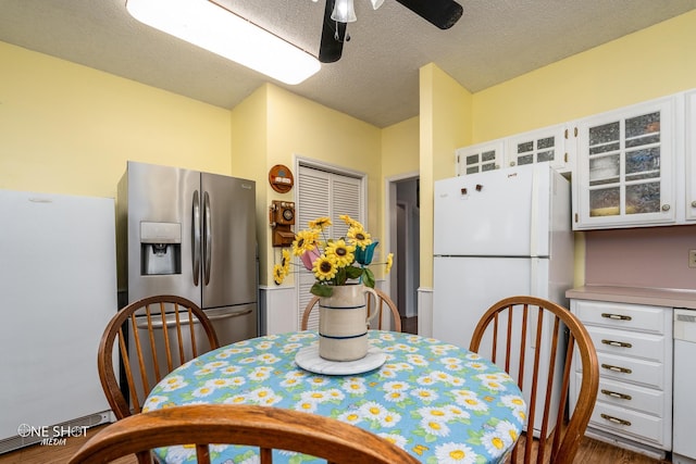 kitchen with light countertops, white appliances, glass insert cabinets, and white cabinetry