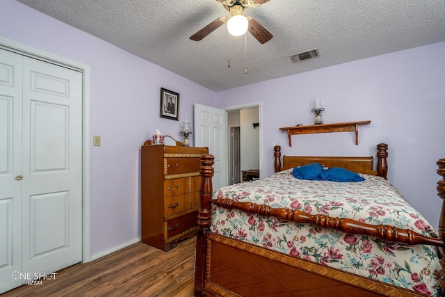 bedroom with visible vents, ceiling fan, a textured ceiling, and wood finished floors