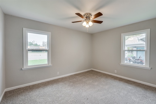 carpeted spare room featuring ceiling fan and a healthy amount of sunlight