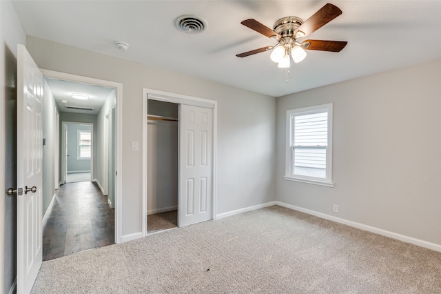 unfurnished bedroom featuring carpet, ceiling fan, and multiple windows