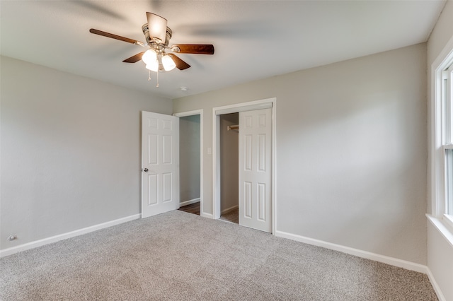 unfurnished bedroom featuring carpet flooring, ceiling fan, and a closet