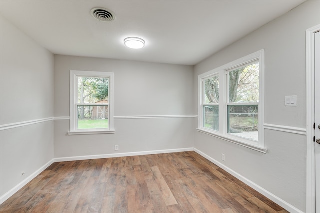 empty room featuring wood-type flooring and a healthy amount of sunlight