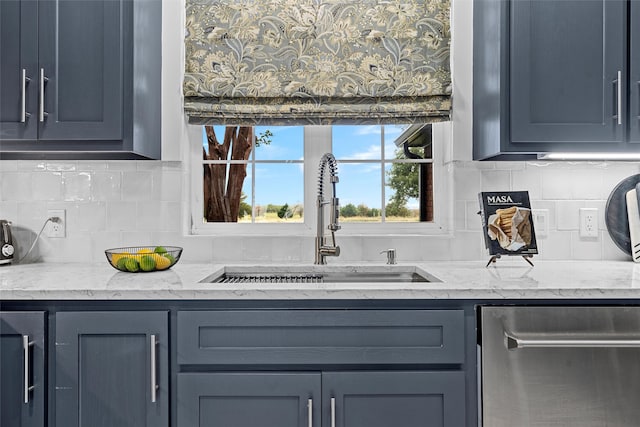 kitchen with backsplash, light stone countertops, sink, and stainless steel dishwasher