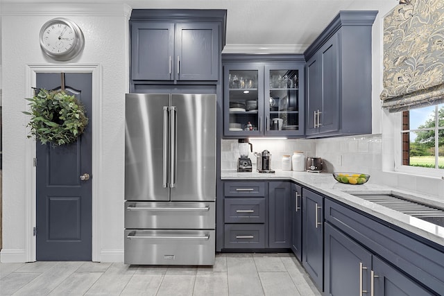 kitchen featuring decorative backsplash, high end refrigerator, light stone counters, and ornamental molding