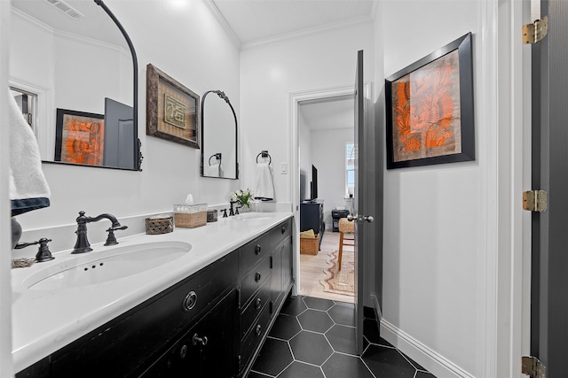 bathroom with crown molding, tile patterned flooring, and vanity