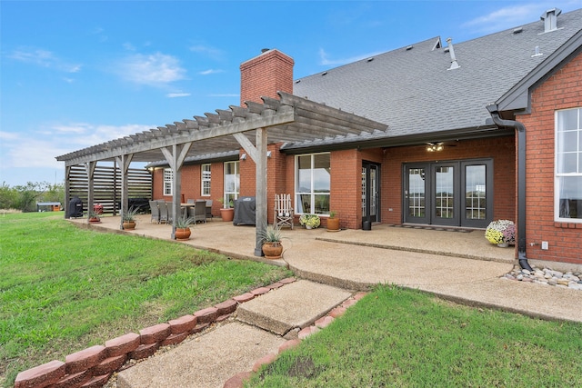 rear view of property with a pergola, a patio area, french doors, and a yard