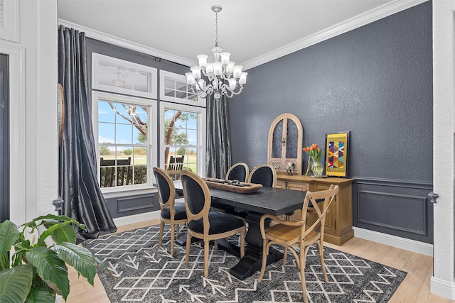 dining area with hardwood / wood-style floors, a notable chandelier, and ornamental molding