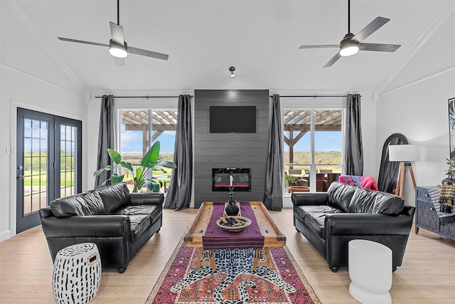 living room featuring plenty of natural light, ornamental molding, and vaulted ceiling