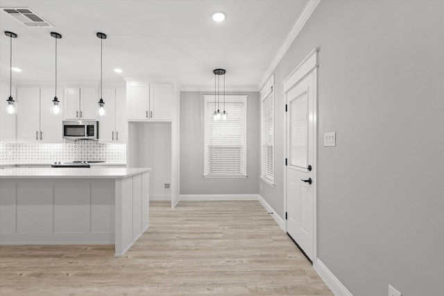 kitchen with white cabinetry, pendant lighting, decorative backsplash, and light wood-type flooring