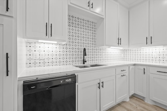 kitchen featuring white cabinets, black dishwasher, tasteful backsplash, and sink