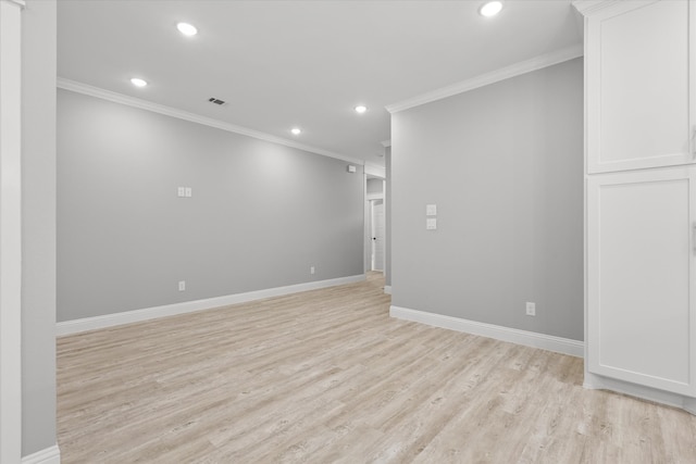 spare room with ornamental molding and light wood-type flooring