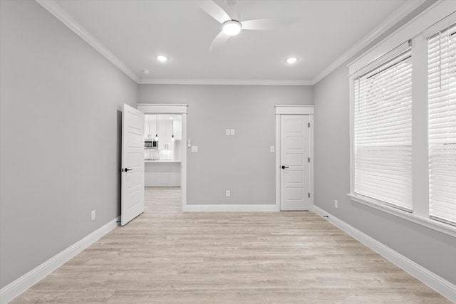 spare room with ceiling fan, light wood-type flooring, and crown molding