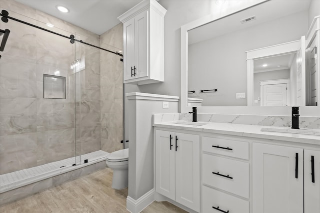 bathroom with vanity, hardwood / wood-style flooring, toilet, and walk in shower