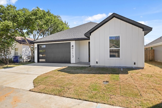 view of front of home featuring a front yard and a garage