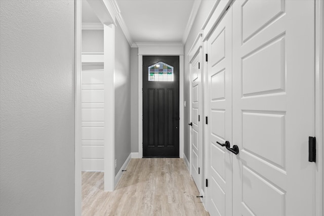 doorway to outside with light hardwood / wood-style floors and crown molding