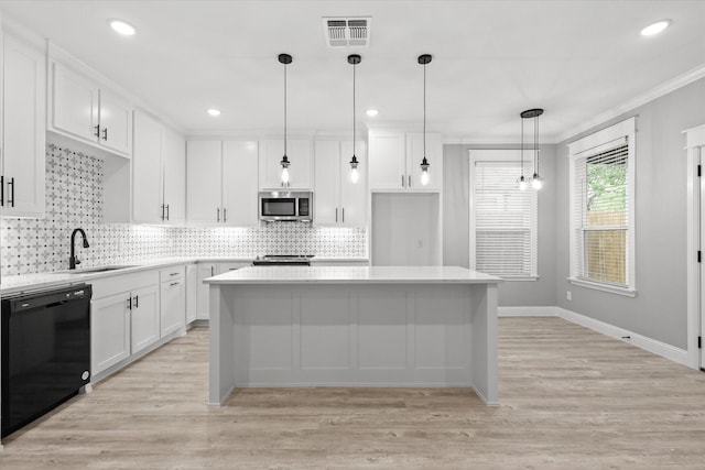 kitchen featuring white cabinetry, appliances with stainless steel finishes, sink, and pendant lighting